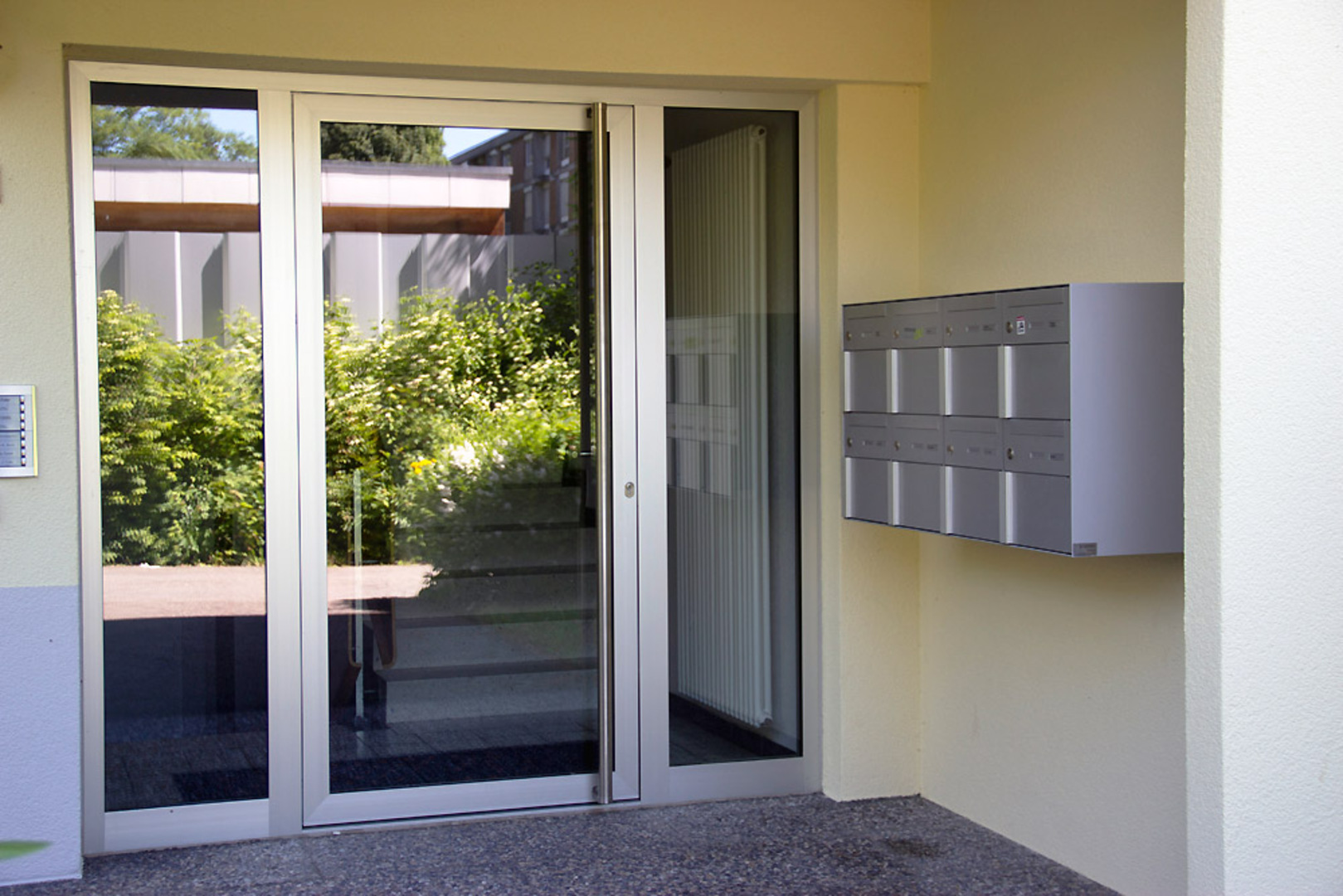 Hauseingang mit Aluminium-Glastüre und Briefkastenanlage